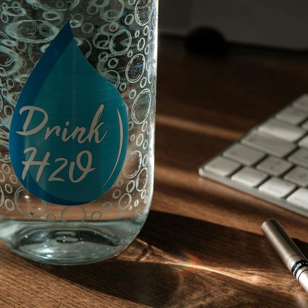 Sleek modern water bottle and stopwatch on a desk